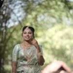 Portrait of a South Indian woman in a traditional saree, exuding elegance and grace in a natural setting.